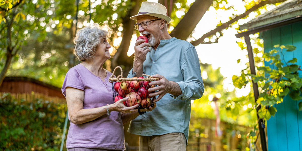 Happy older people eating an apple